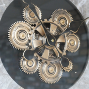 Stylish oversized clock combining natural wood, brushed metal, and marble elements with functional-looking cogs, 87cm tall by 74cm wide by 9cm deep, 9kg.