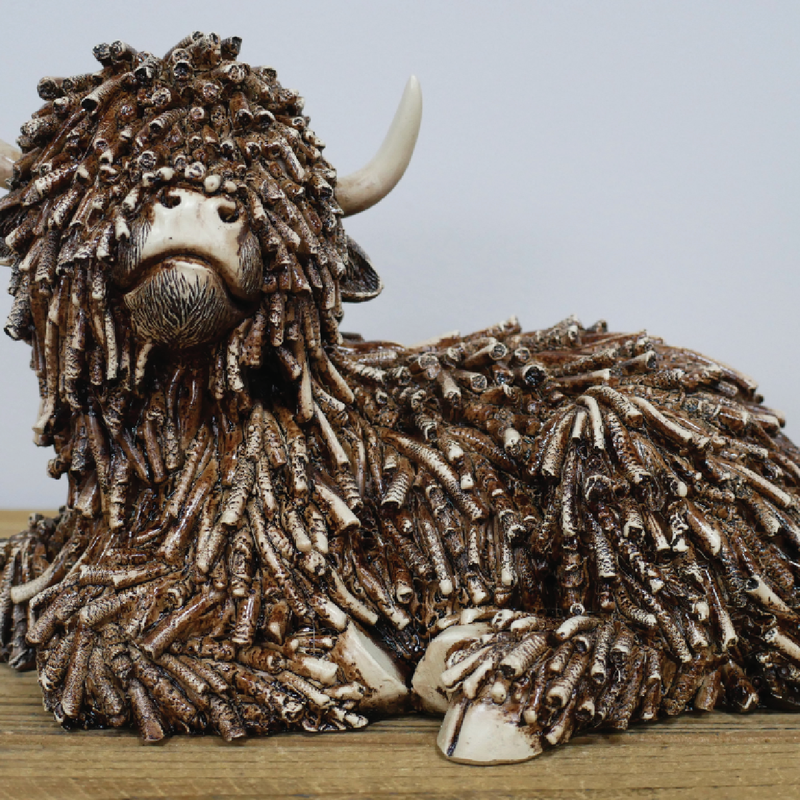 Whimsical cow ornament depicted lying down, perfect for shelf or tabletop display, 17 × 25 × 15cm, 0.83kg.