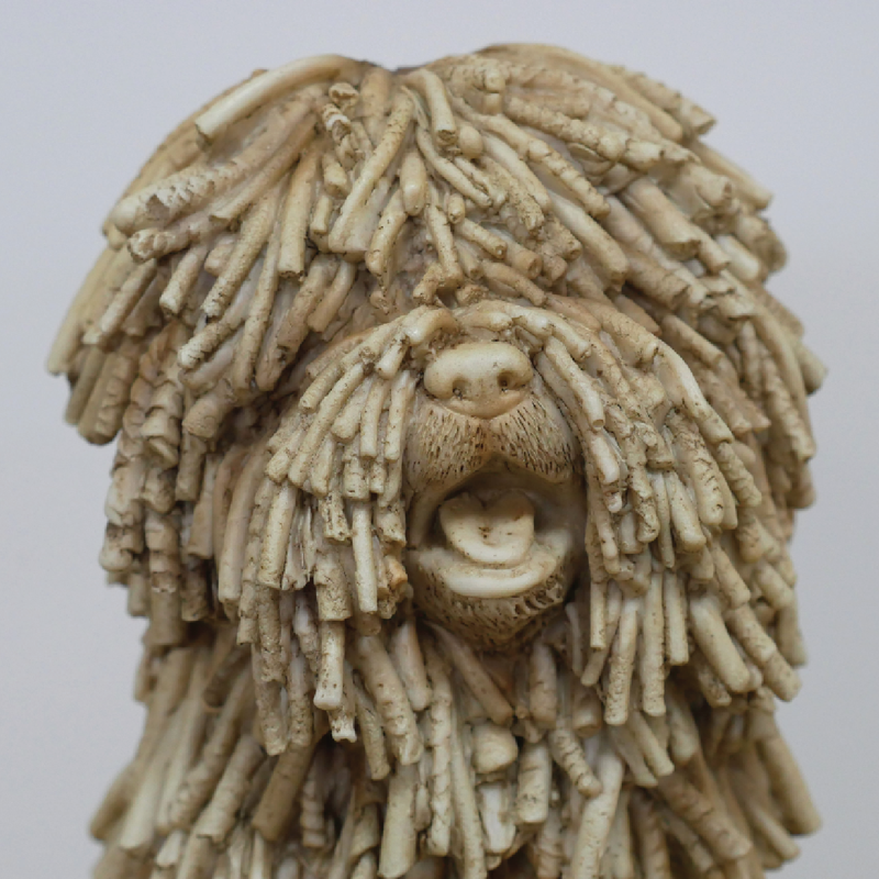 Decorative figurine of a seated shaggy dog with textured fur detailing, dimensions 26cm H × 16cm W × 21cm D, weight 1.25kg.