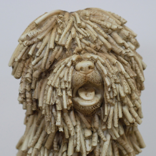 Decorative figurine of a seated shaggy dog with textured fur detailing, dimensions 26cm H × 16cm W × 21cm D, weight 1.25kg.