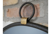 Contemporary round wall mirror featuring a minimalist black bezel highlighted with refined gold detailing.